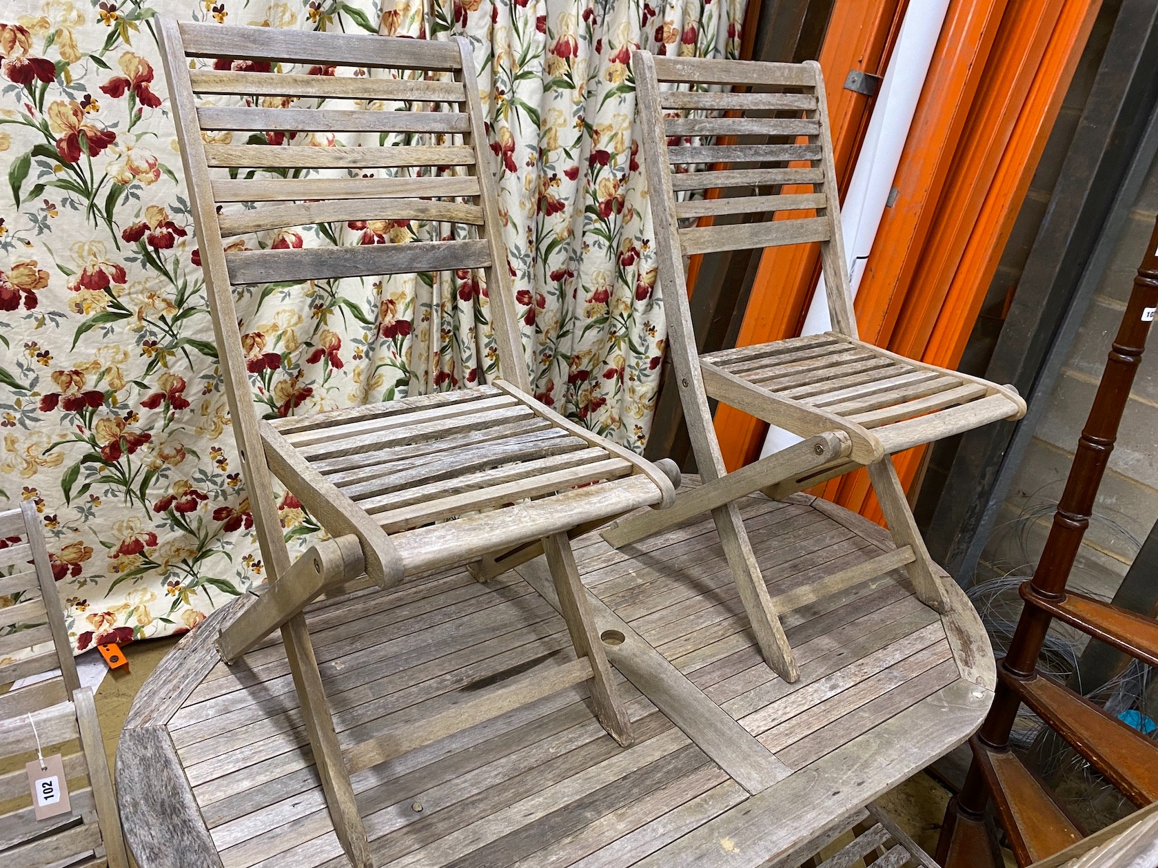 A weathered teak folding garden table, length 152cm, width 90cm, height 75cm and six teak folding garden chairs